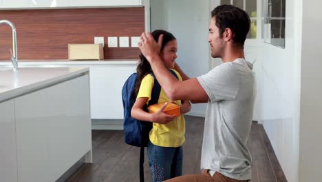 padre feliz besando a su hija listo para la escuela