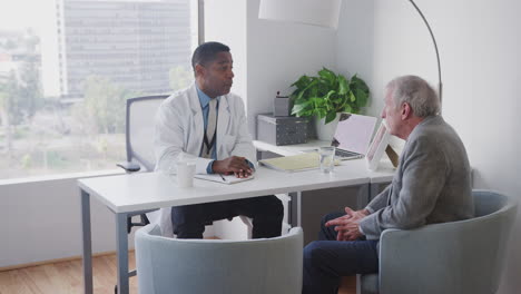 senior male patient having hospital consultation with doctor in office