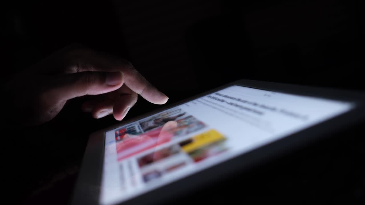 persona que usa una tableta por la noche