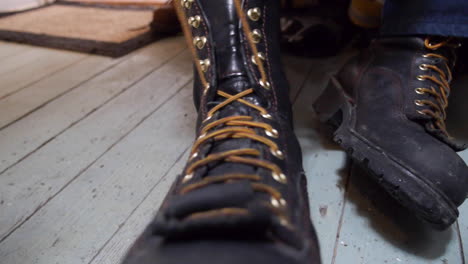 grandes botas negras atadas dentro del apartamento durante el invierno por el trabajador