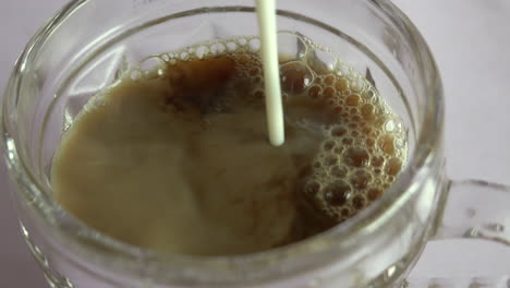 vista de ángulo superior de verter leche en una taza de café