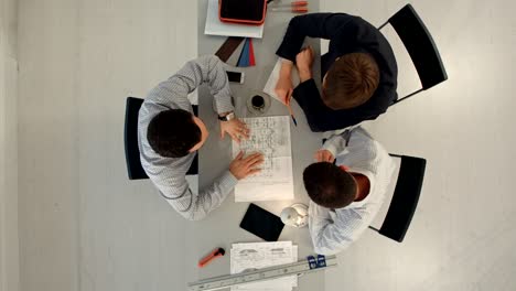 arquitectos con planos en el sitio de construcción. construcción, arquitectura, negocios, trabajo en equipo y concepto de personas. vista superior