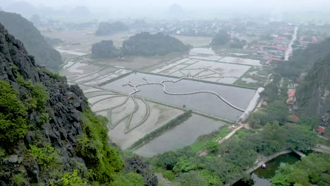 tam coc rice fields on a foggy day from hang mua viewpoint in ninh binh, vietnam. - ascend shot