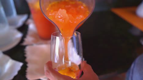 pouring passion fruit or maracuja juice into glass