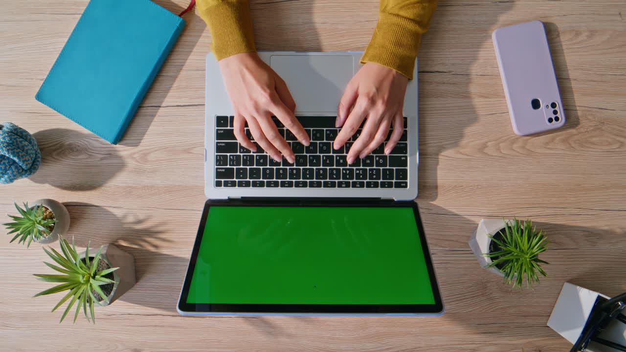 Hands typing mockup laptop keyboard on desk in professional workspace top view