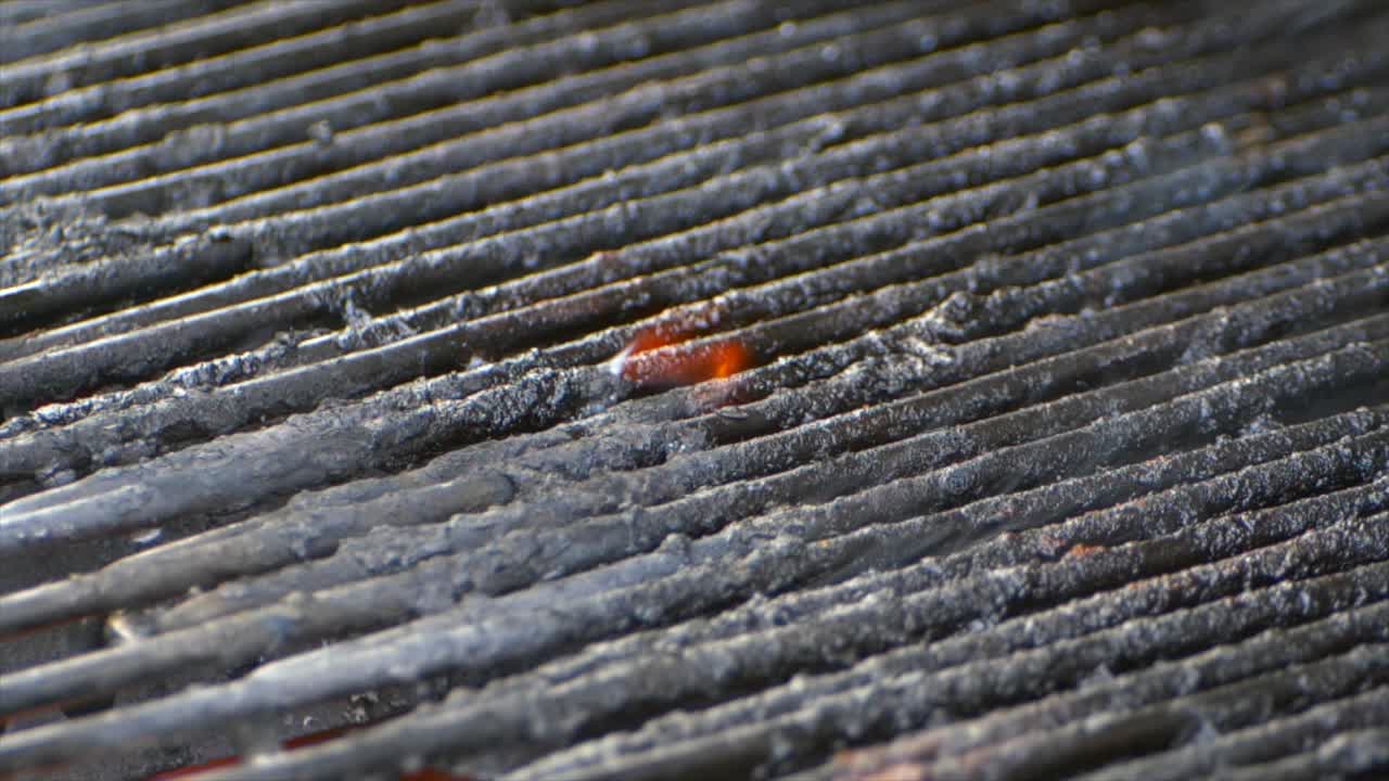 불이 붙은 그릴에 있는 오래된 음식에 작은 불꽃이 타오른다