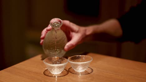 sequence of pouring sake from bottle to cups