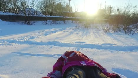 little girl falling in snow. child in winter park. sunny winter day