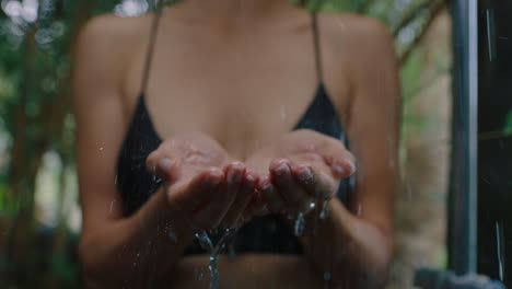 woman-in-shower-catching-water-in-hands-enjoying-refreshing-cleanse-showering-outdoors-in-nature