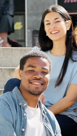 two young diverse adults smiling outdoors