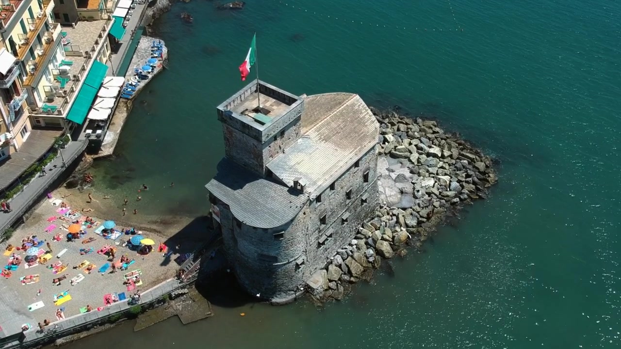 Drone che si inclina verso il Castello di Rapallo, in una giornata estiva e soleggiata in Liguria, Italia.