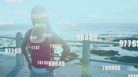 varios números cambiantes contra una mujer afroamericana tomando un descanso de correr en el paseo marítimo