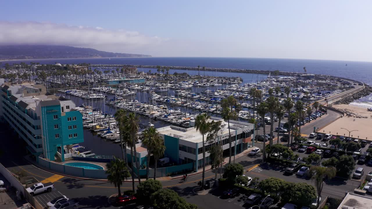 캘리포니아 주 레돈도 해변의 팔로스 베르데스 반도를 바라보는 킹 하버 마리나의 낮은 리버스 풀백 공중 촬영