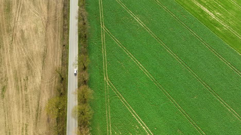 A-top-down-aerial-view-of-a-field-divided-by-a-road