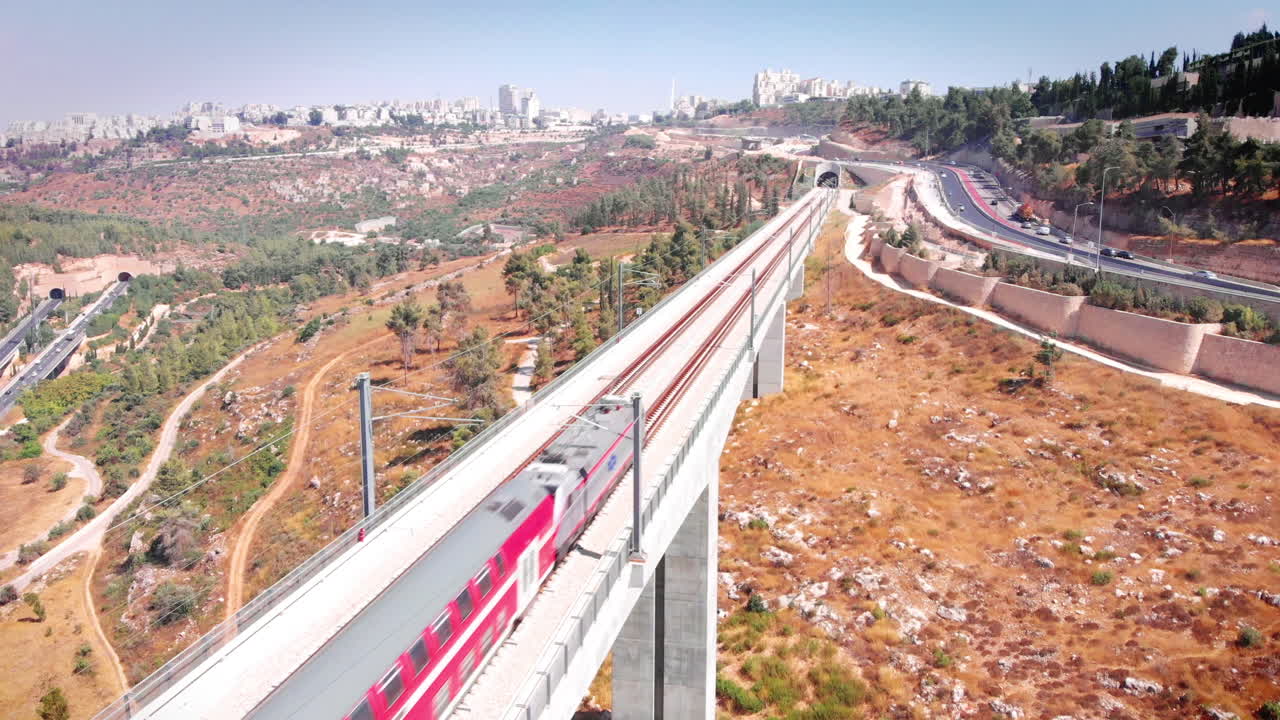 Modern passenger train crossing a bridge in the outskirts of Jerusalem, Aerial footage