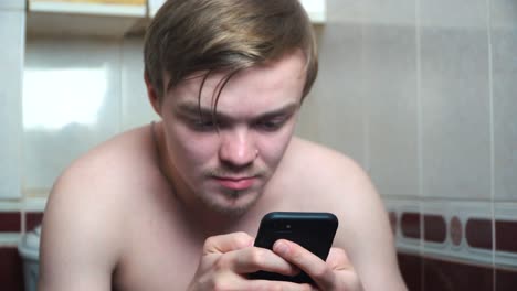 man using phone in a bathroom