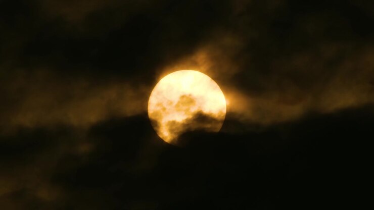 Bright yellow Full Moon with dark clouds moving across slowly