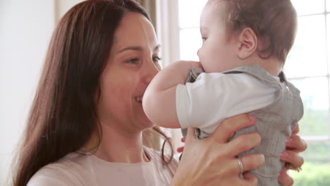 Madre-Jugando-Con-Niño-Feliz-En-El-Sofá-En-Casa