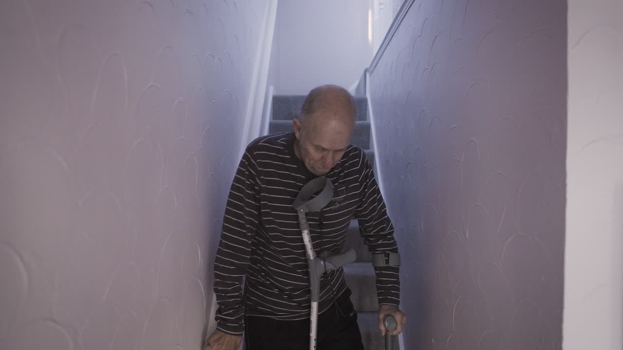 Senior man with crutches on stairs