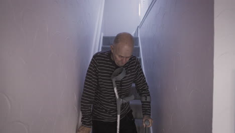 senior man with crutches on stairs