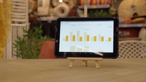 the tablet on the stand in the retail store shows bar chart data. used for business analytics, stock control, and sales tracking in modern retail environments.