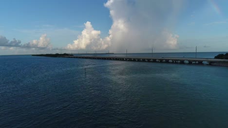 Aerial-shot-moving-towards-the-overseas-highway-in-the-Florida-Keys-rising-above-the-highway-to-reveal-long-road-along-the-ocean