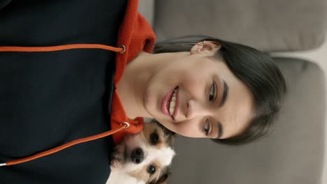 retrato de una mujer morena con un pequeño perro jack russell terrier en su hombro mirando a la cámara