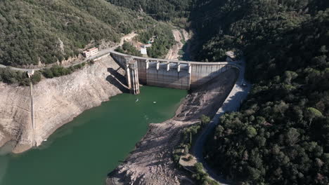 Aerial-view-approaching-woodland-valley-Sau-reservoir-with-scenic-Catalan-river-Ter-in-low-supply