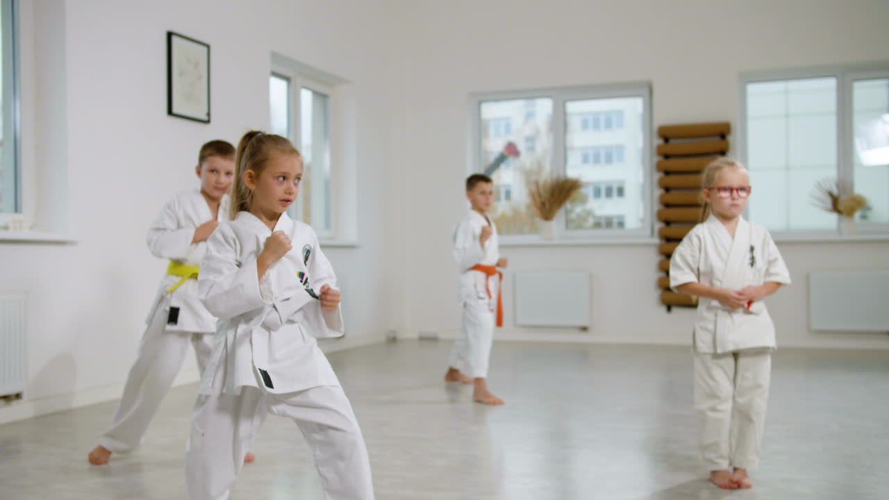 niña con kimono blanco en la clase de artes marciales