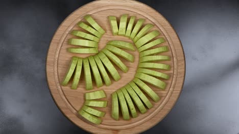 sliced zucchini on a wooden kitchen board. top view. loop motion. rotation 360.