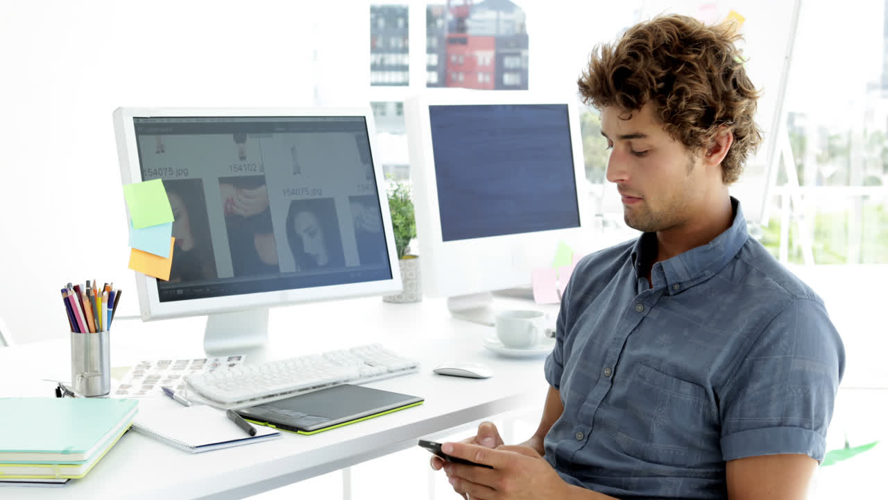 el guapo diseñador creativo enviando mensajes de texto con su teléfono