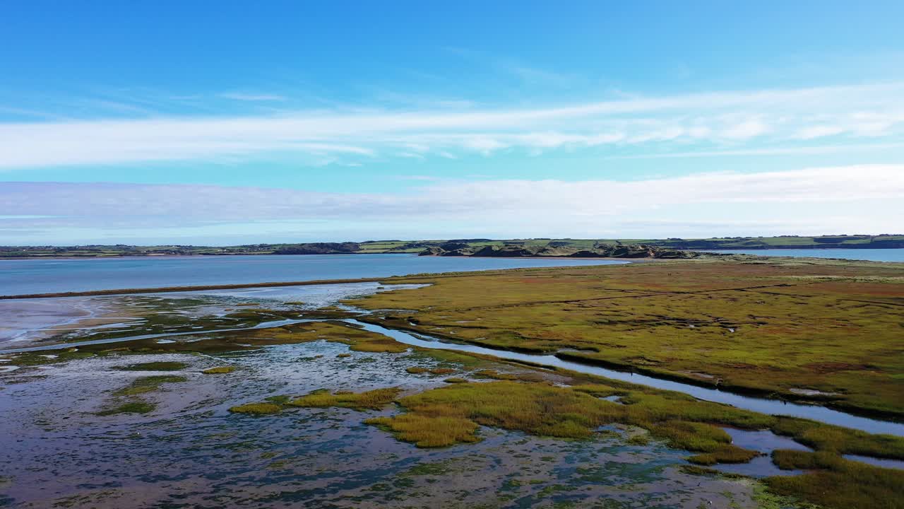 drone gran angular sobre campo verde cerca de la playa de tramore, irlanda en verano