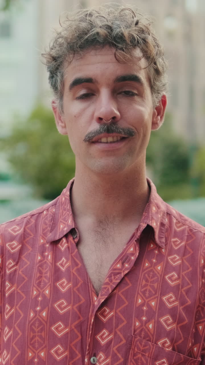 Homem com Cabelo Cacheado e Bigode Abre os Olhos e Sorri