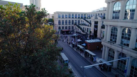 arcing shot of trams entering and leaving the station dropping off commuters in montpellier