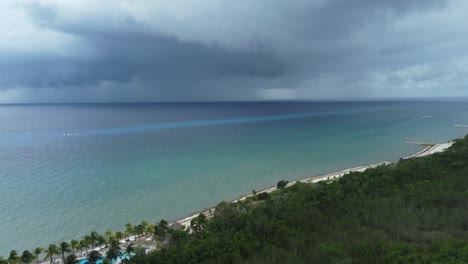 cozumel coastline with approaching storm, dark clouds over turquoise sea, tropical beachside, aerial view