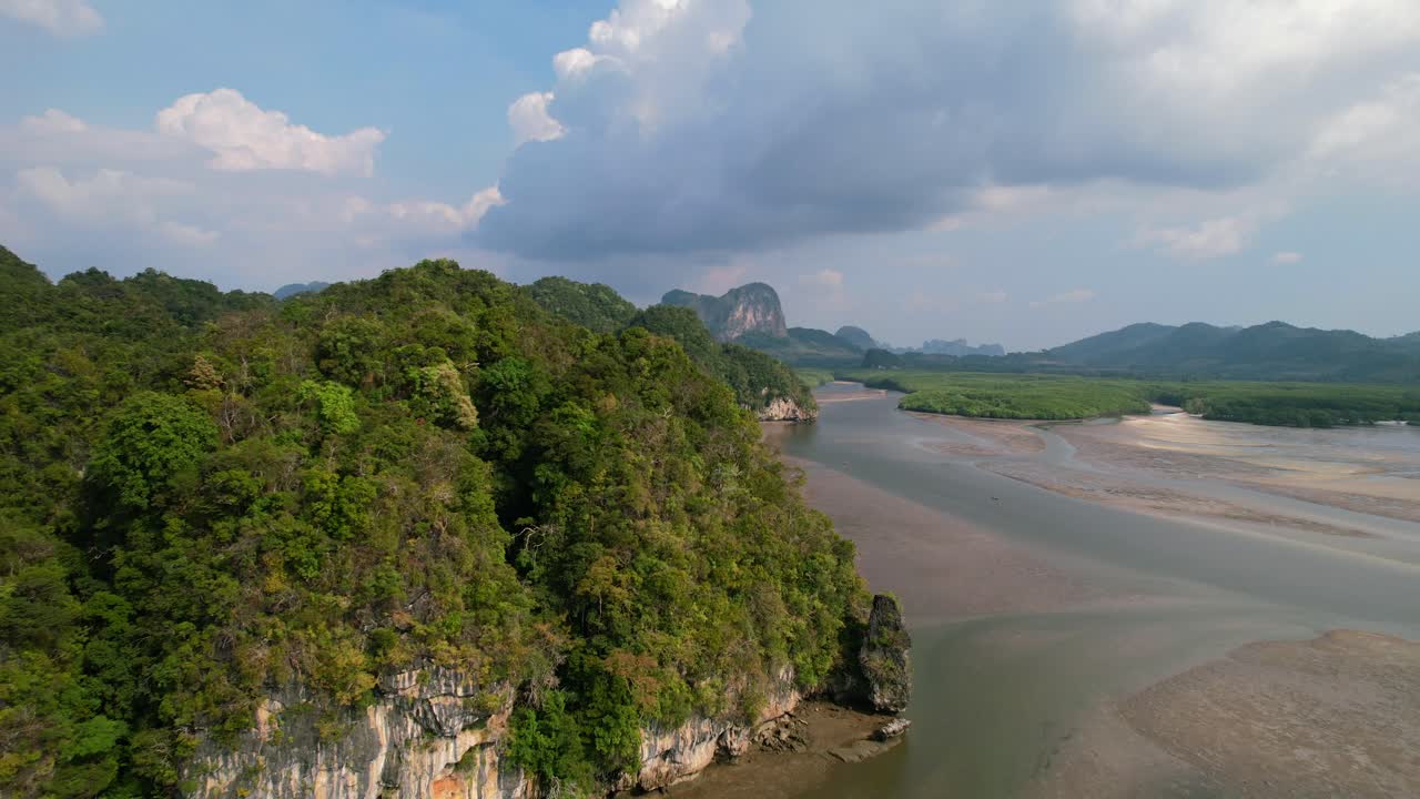 drone pasando una montaña de piedra caliza que revela el río, los manglares y el banco de arena durante la marea baja en un día soleado en ao thalane krabi tailandia