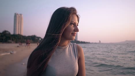 happy lady in dress walks along ocean at beach slow motion