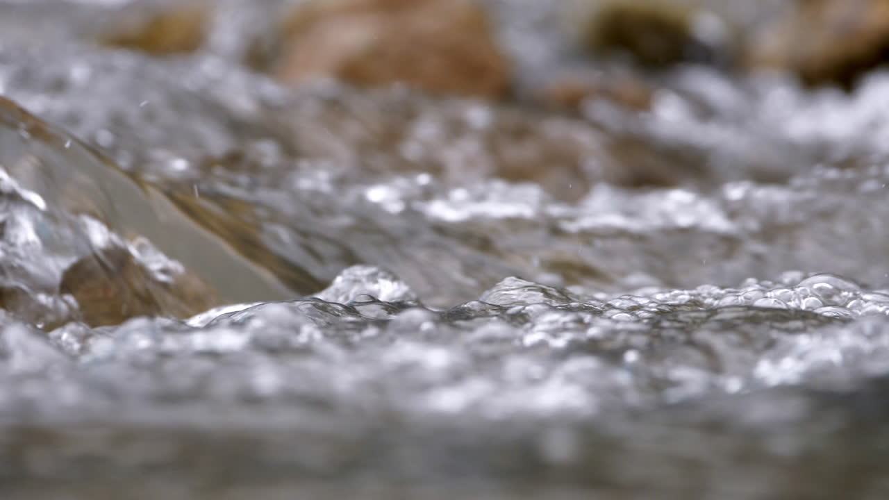 Clear stream running through stone boulders Abundant river flowing in slow motion