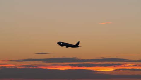 Schwarze-Silhouette-Eines-Fliegenden-Flugzeugs-Am-Abendhimmel