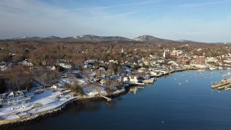 aerial footage flying forward and down into a quiet camden harbor on a cold winter morning