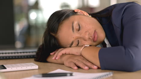 mujer cansada durmiendo en su escritorio en la oficina