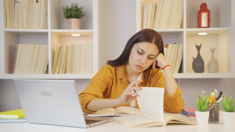 una estudiante se duerme mientras estudia.