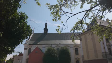 a beautiful view of the parish of the most holy name of jesus in wroclaw, poland, showcasing its historic architecture against a clear blue sky. pan left shot