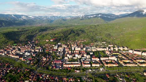 4K-Kinoaufnahmen-Aus-Der-Luft-Mit-Einer-Drohne,-Die-Eine-Wunderschöne-Stadt-In-Den-Großen-Karpaten-Mit-Den-Bergen-Im-Hintergrund-Zeigt,-Gefilmt-Mit-Mini-3-Pro