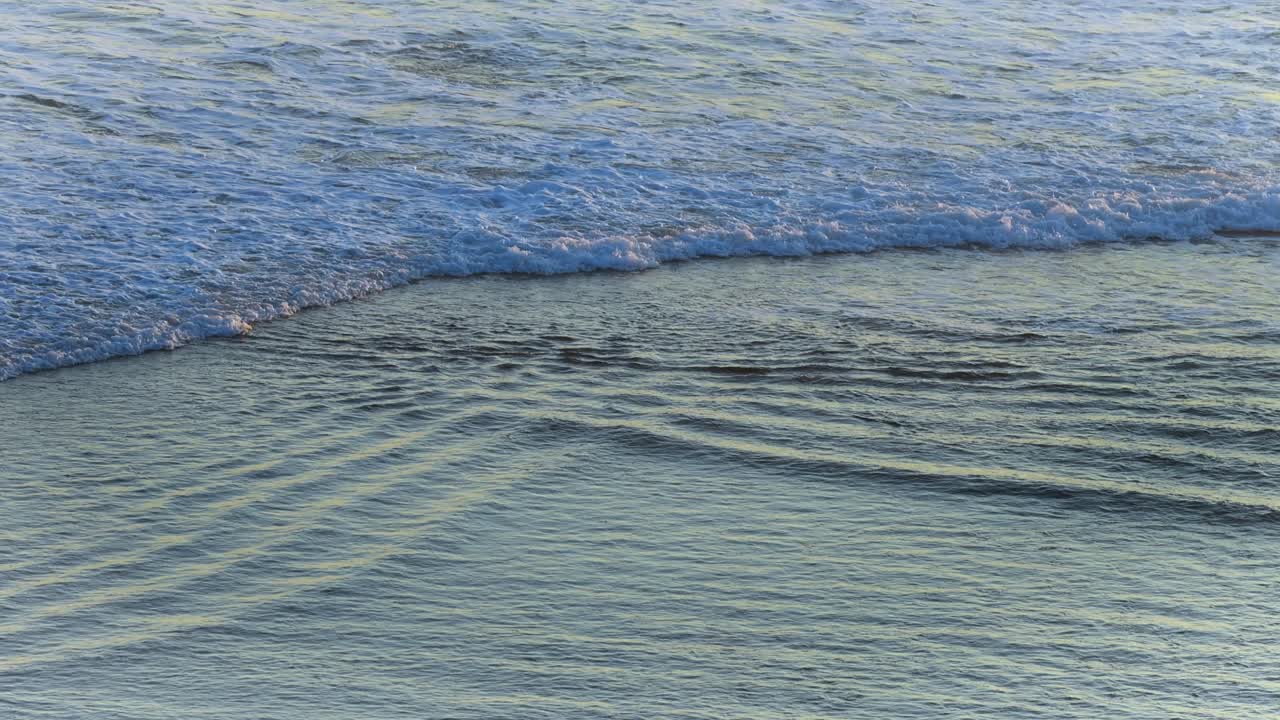 파도가 부드럽게 해변으로 굴러갑니다.