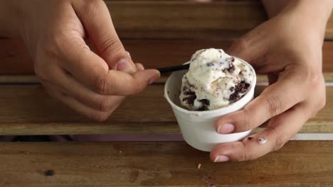 las mujeres toman helado con una cuchara de una taza.
