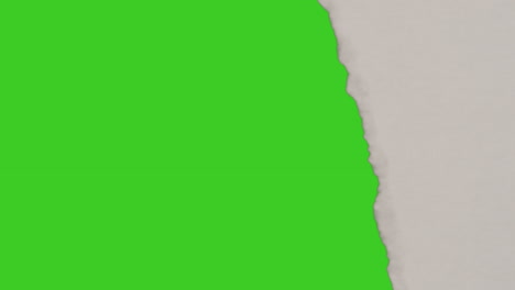 close up of strip of paper being torn off uncovering green screen background below 7