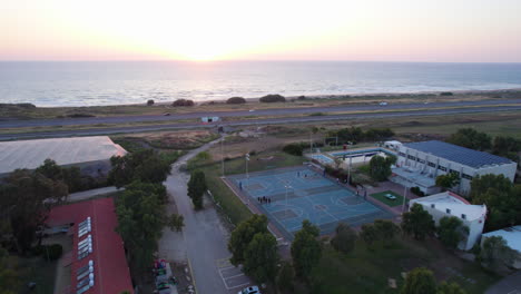 niños jugando en una cancha de baloncesto junto al mar al atardecer - disparo de paralaje