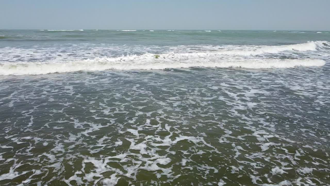 Aerial side track view of Cape Point, Bakau - The Gambia, cinematic sliding right low over the sea