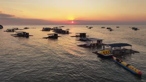 Silueta-De-Personas-En-El-Agua-Y-Estacionamiento-De-Botes-De-Madera-En-La-Playa-En-Filipinas